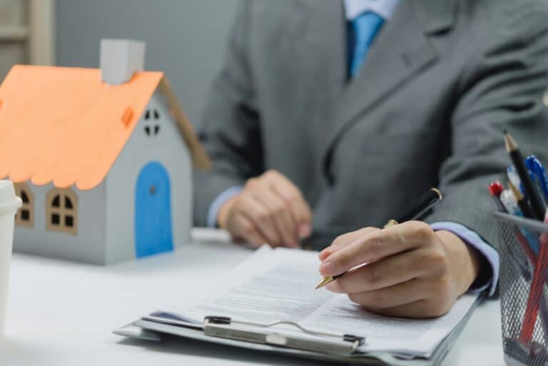 businessman holding a pen signing a house purchase contract. Real estate